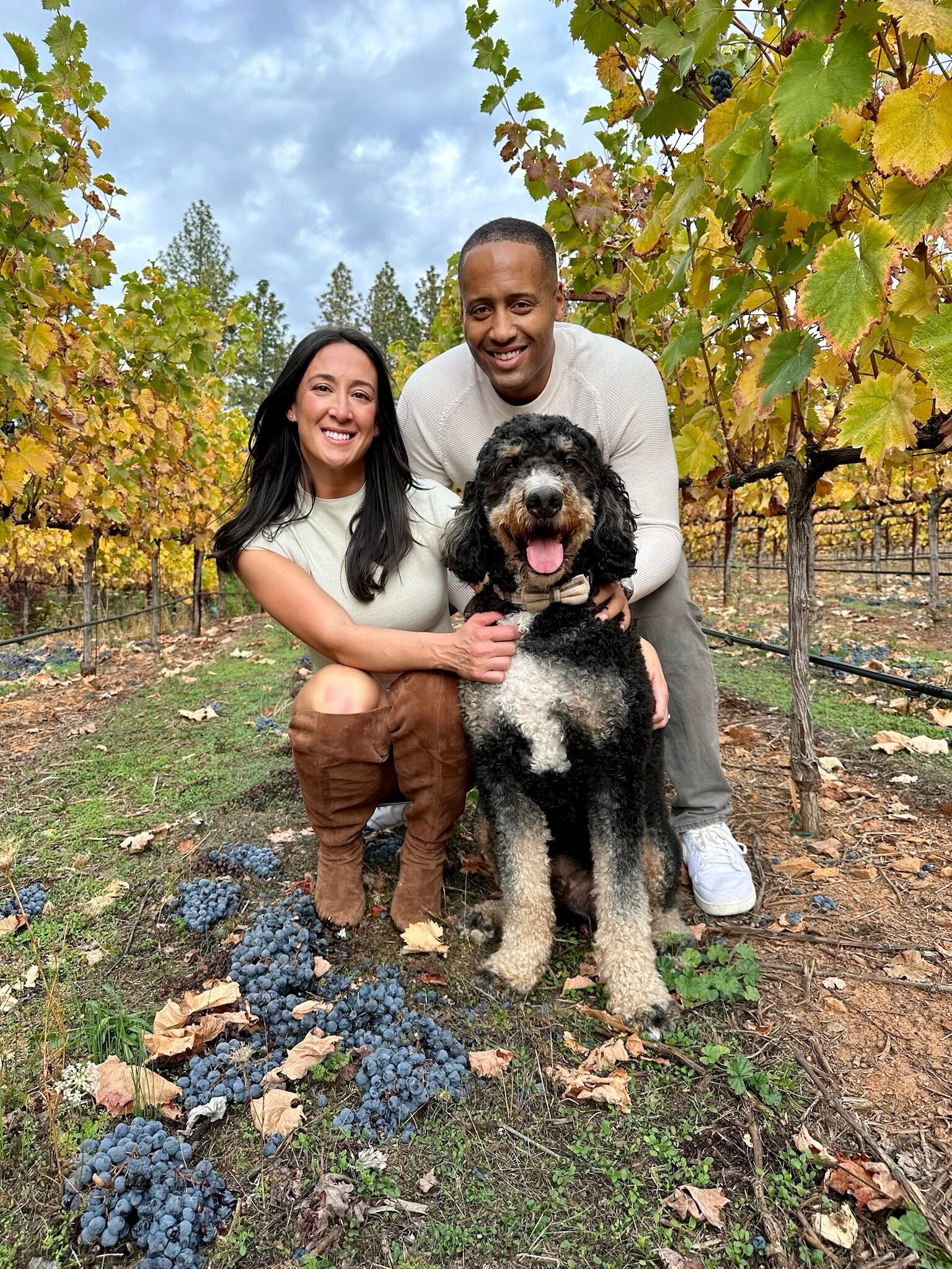 Couple with dog in vineyard, autumn day.