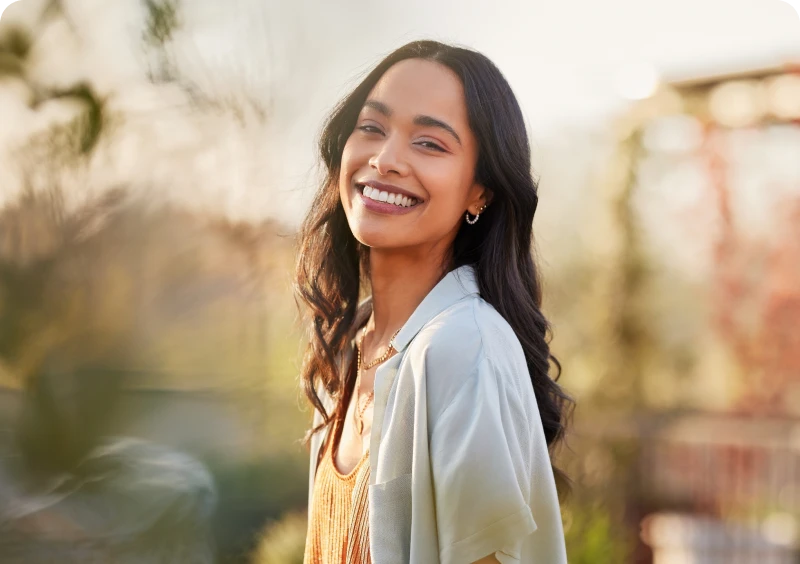 Cheerful woman with long hair outside.